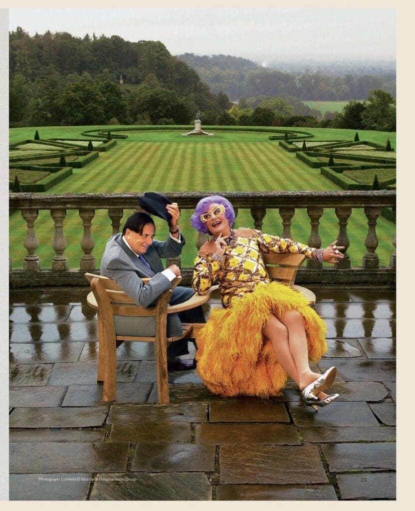 A trick colour shot of Barry sitting next to Dame Edna. On a love seat the dress she is wearing was lot 240 which sold for £29,160 vs an estimated £1,500-2,000