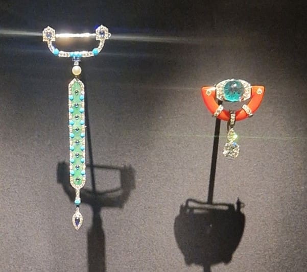 Jade and turquoise brooch, 1913; carved emerald, coral and diamond brooch, 1925